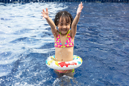 Asian Little Chinese Girl Playing in Swimming Pool with Swimming Circleの写真素材