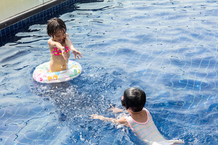Asian Little Chinese Sisters Playing in Swimming Pool Outdoorの写真素材