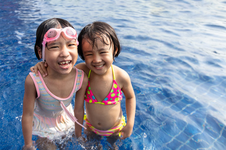 Asian Little Chinese Sisters Playing in Swimming Pool Outdoorの写真素材