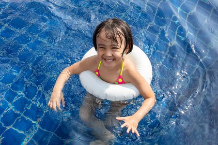 Asian Little Chinese Girl Playing in Swimming Pool Outdoorの写真素材