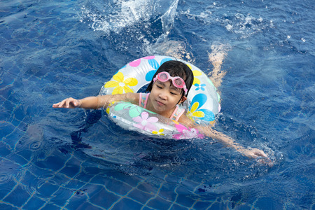 Asian Little Chinese Girl Playing in Swimming Pool with Swimming Circleの写真素材