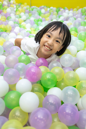 Asian Chinese little Girl Playing At Balls Pool in Indoor Playgroundの写真素材