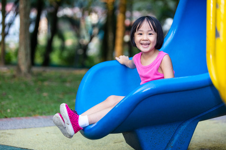 Asian Chinese little girl playing at outdoor playground aloneの写真素材