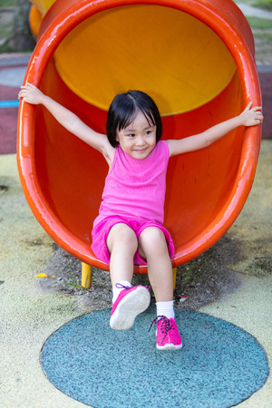 Asian Chinese little girl playing at outdoor playground aloneの写真素材