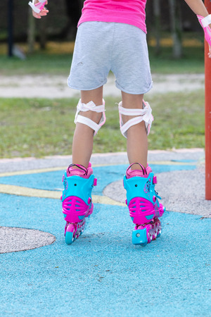 Little girl playing with roller skates at outdoor playgroundの写真素材