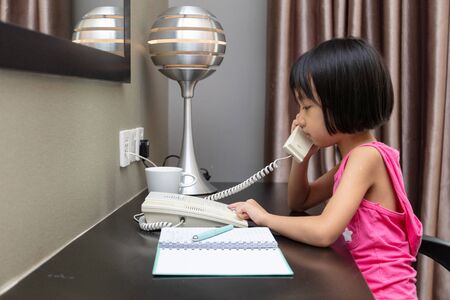 Asian Little Chinese Girl making calls at homeの写真素材