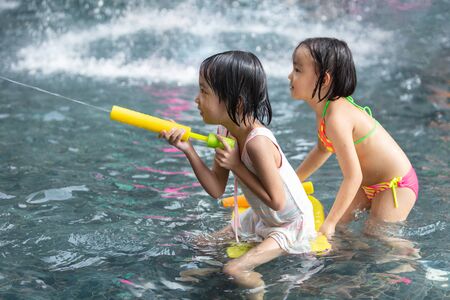 Asian Little Chinese Sisters playing at water park outdoorの写真素材