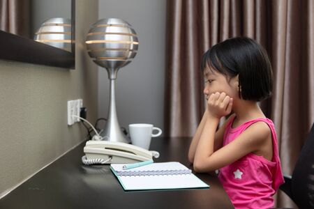 Asian Little Chinese Girl doing homework at homeの写真素材