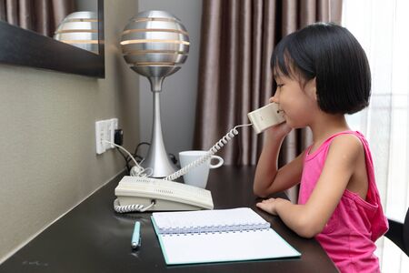 Asian Little Chinese Girl making calls at homeの写真素材