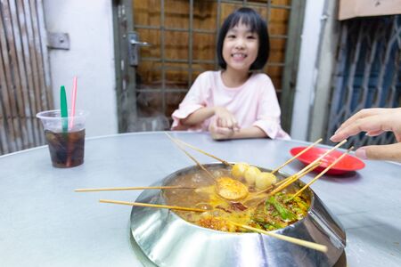 Asian Little Chinese Girl eating hot pot in a restaurant of Melakaの写真素材