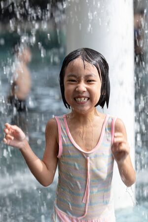 Asian Little Chinese Girl playing at water park outdoorの写真素材