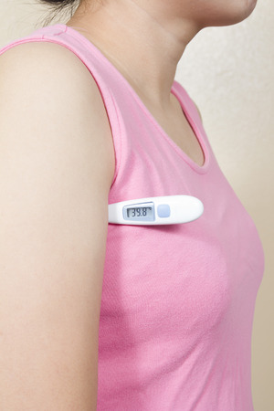  woman having flue taking thermometerの写真素材