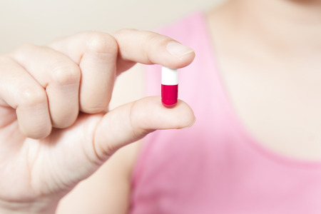 woman holding a pill ,Close-up of woman hand holding pillの写真素材