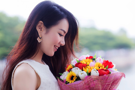 Asia young cute woman smelling  flowersの写真素材