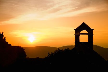 Black tower at the time of orange sunset with beautiful clouds and mountains in Old Bar, Montenegroの写真素材