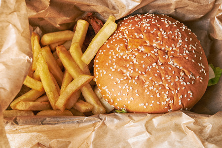 hamburger and french fries in paper/ take away food/ top view