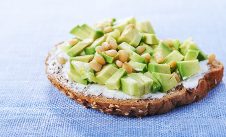 open sandwich with chopped avocado and cedar nuts