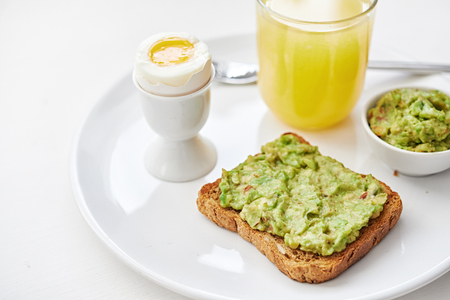breakfast with avocado toast, orange juice and boiled egg.  の写真素材