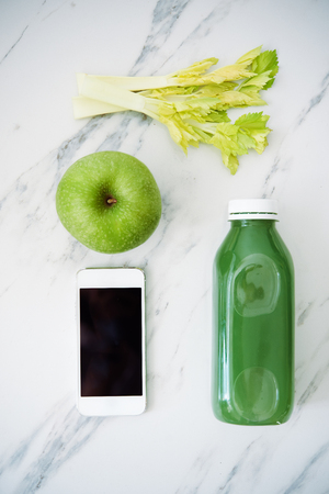 green juice bottke, vegetables and smartphone. top view. diet conceptの写真素材