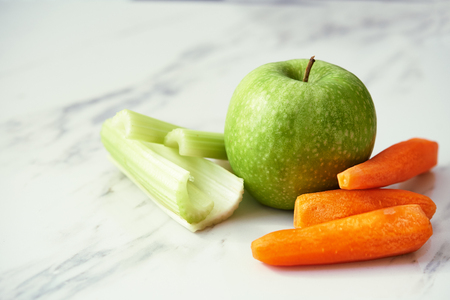green apple, carrots and celery on marble backgroundの写真素材