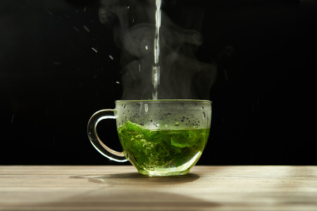 hot water and mint leaves in glass cupの写真素材