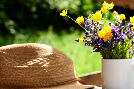 wild flowers and summer srtaw hat at sunny dayの写真素材