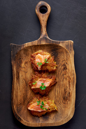 hash browns and salmon on wooden plate. top viewの写真素材