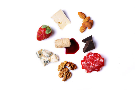 cheese, nuts, meat, chocolate, honey and strawberry and red wine spot isolated on white backgroundの写真素材