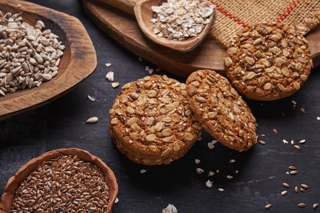 oats and seeds cookies and ingredients on wooden background.の写真素材
