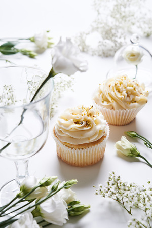 vanilla cupcakes and white flowersの写真素材