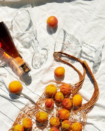fruits and bottle of wine with glases on white cotton wrap at sunny day. top view,  deep shadowsの写真素材