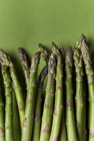 bunch of fresh asparagus on green background. top viewの写真素材