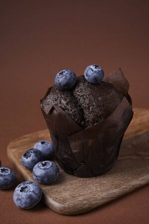 chocolate muffin with blueberries on wooden backgroundの写真素材
