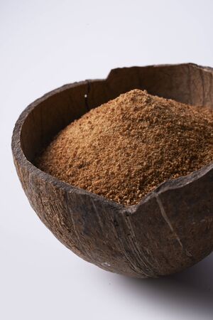 half of coconut's shell  with coconut sugar  on white background.の写真素材