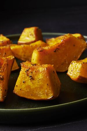 pieces of roasted pumpkin with herbsの写真素材