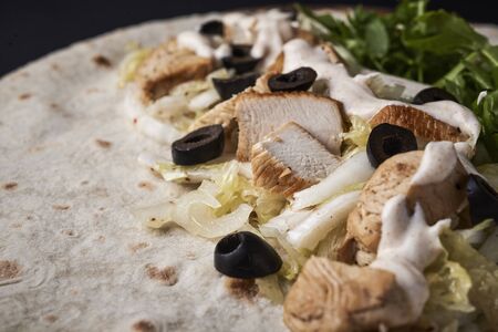 chicken, salad and olives on flat bread