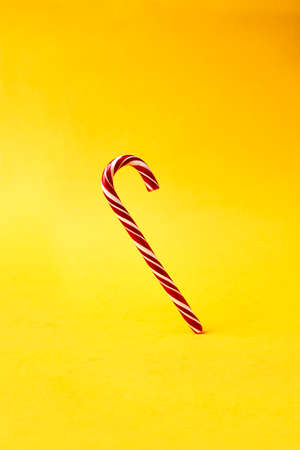 christmas striped candy stick on vivid orange backgroundの写真素材