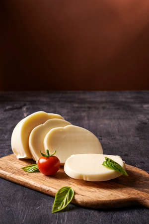 cheese on wooden board with cherry in rustic styleの写真素材