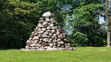 Many stones piled by a pyramid in the Latvian village of Malpils. May 2019.のeditorial素材