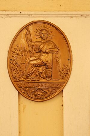 Female bas-relief, as a symbol of greatness, is made in a plaster of a large oval on the wall of a house in the Corsican city of Ajaccio. France, September 2019.のeditorial素材
