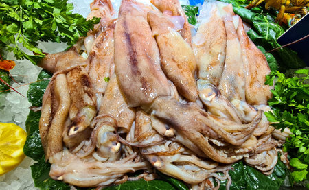 Many carcasses of squid on green leaves in the seafood restaurant are prepared for visitors