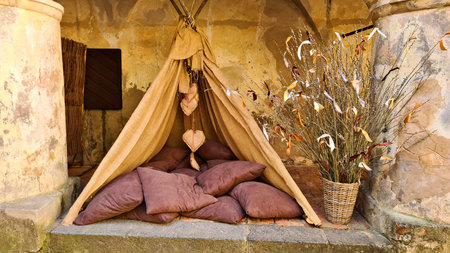 An impromptu small hut with many pillows against stone wall