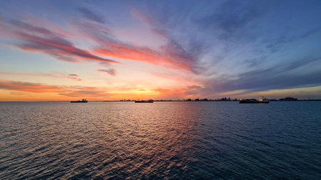 The first rays of the rising sun against the background of distant shore from the seaの写真素材