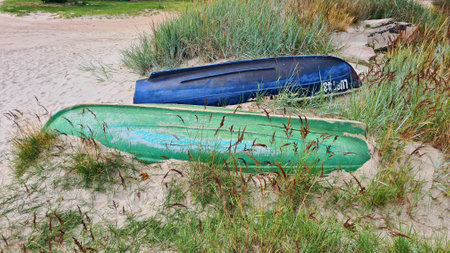 Two pleasure boats lie upside down on the sand among the dunesの写真素材