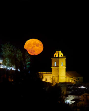 Full moon rise over town, in Atea, Alicante, Spain, full moon next to church, moon rise on the Costa Blancaの写真素材