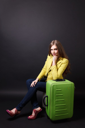 Pretty woman waiting with a suitcaseの写真素材
