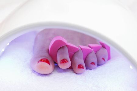 Pedicure foot and nails treatment with UV lamp