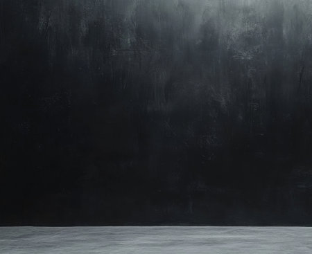 Studio with a dark wall and plain concrete floor.の素材