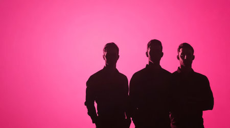 Three men silhouettes on pink backdropの素材