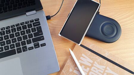 Mobile phone and smart watch on a dual wireless charger with a stylus concept for wireless technology and portable information devicesの写真素材